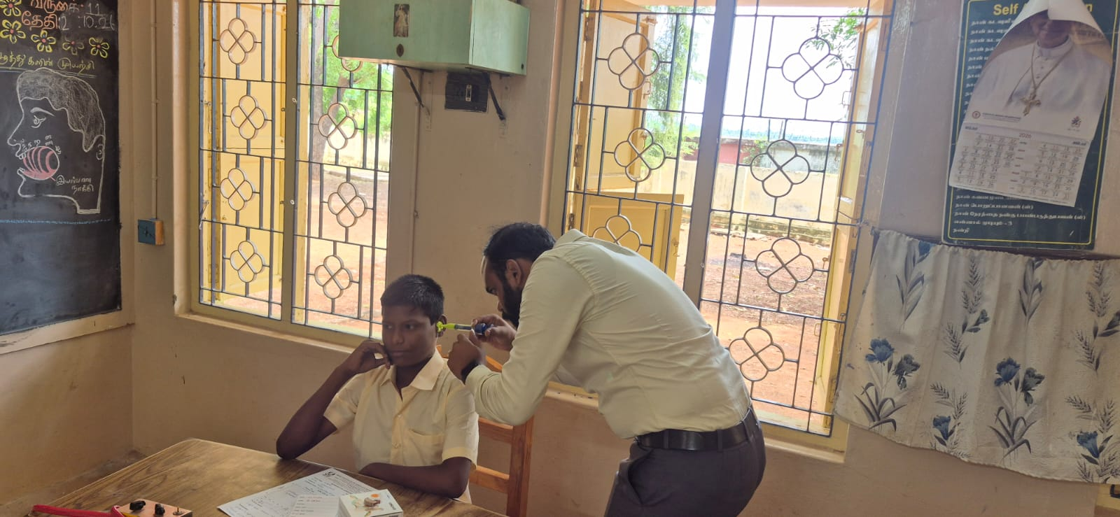 Audiologist performing ear examination for a student at Trichy camp