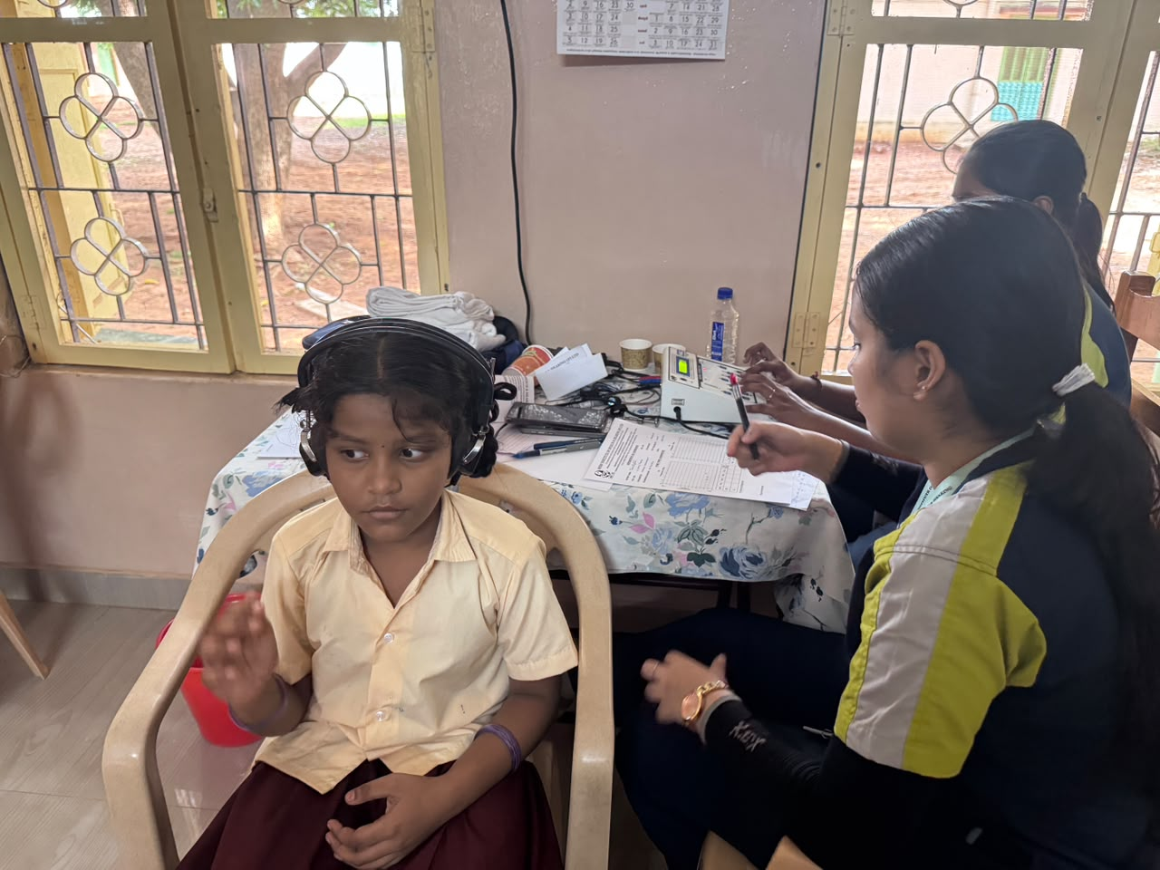 Child undergoing hearing test with headphones at Dolours School, Trichy