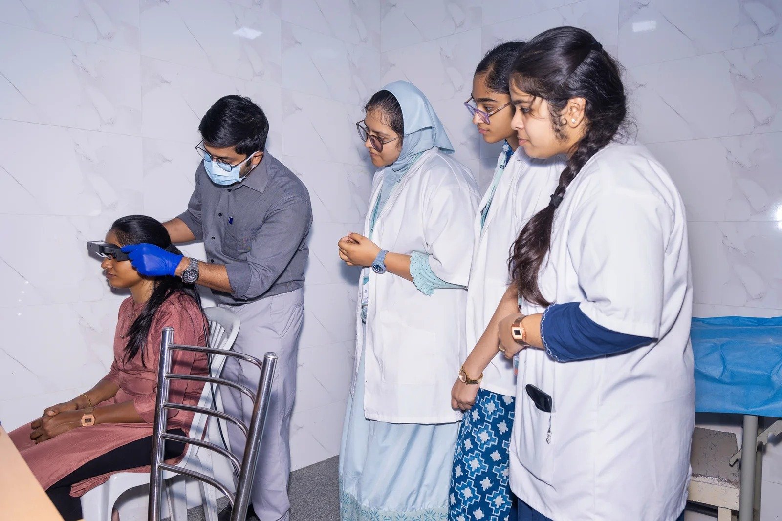 Patient holding their head for support while experiencing dizziness and imbalance in a clinic setting.